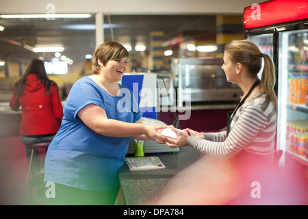 Young woman collecting takeaway order in cafe Stock Photo