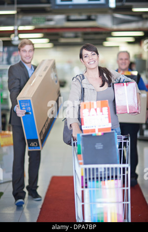 Woman leaving showroom with abundance of purchases Stock Photo