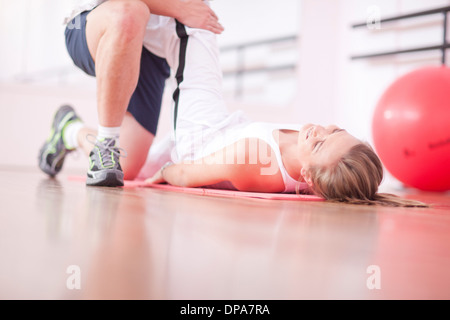 Personal trainer with client in gym Stock Photo