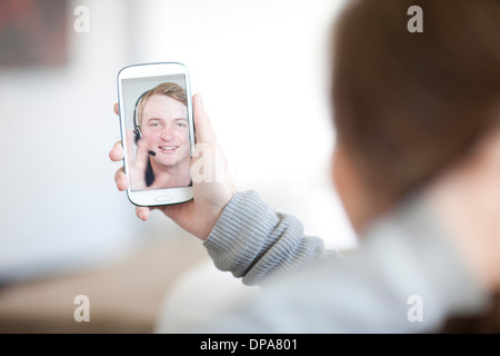 Young woman making video call on cellphone Stock Photo