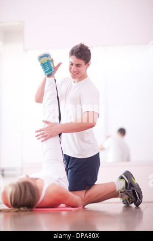 Young man training with client in gym Stock Photo