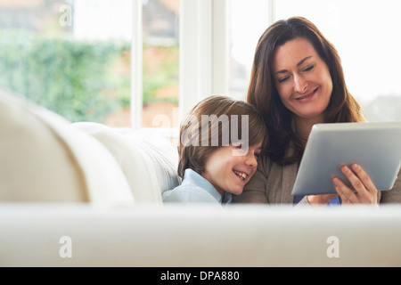 Mother and son on sofa using digital tablet Stock Photo