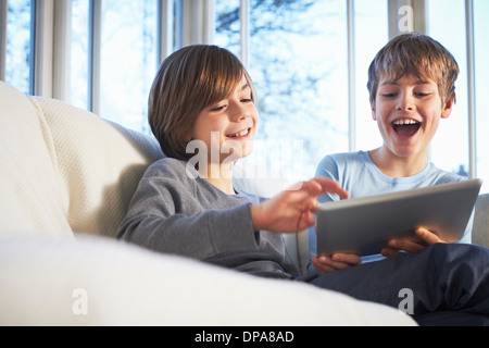 Brothers using digital tablet together Stock Photo