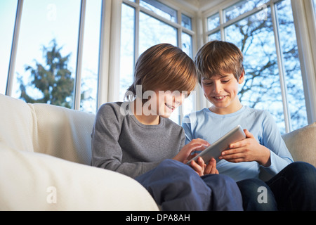 Brothers using digital tablet together Stock Photo