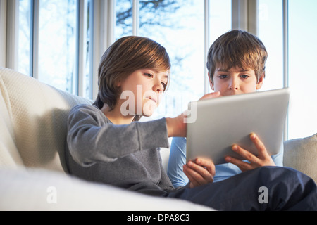 Brothers using digital tablet together Stock Photo