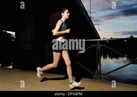 Young woman running at sunset Stock Photo