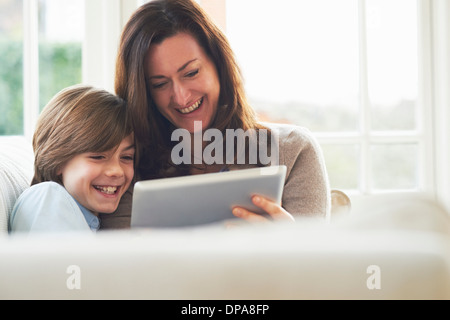 Mother and son on sofa using digital tablet Stock Photo