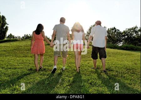Group of young adults walking and holding hands Stock Photo