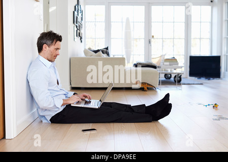 Man sitting on floor using laptop Stock Photo
