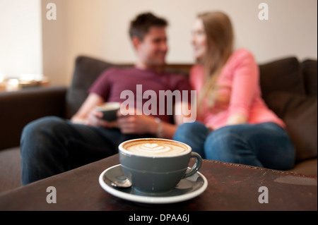 Young couple lounging on sofa in cafe