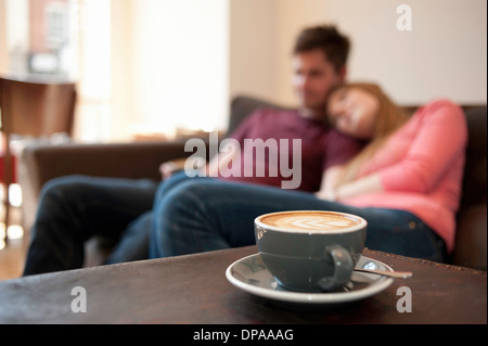 Young couple lounging on cafe sofa