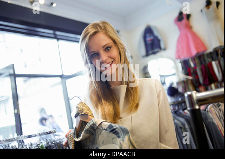Woman holding top garment and scarf Stock Photo