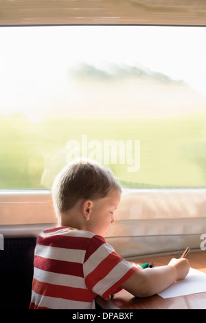 Young boy drawing on train Stock Photo