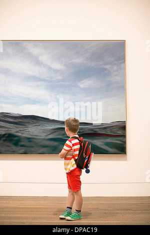 Young boy looking at picture in gallery Stock Photo