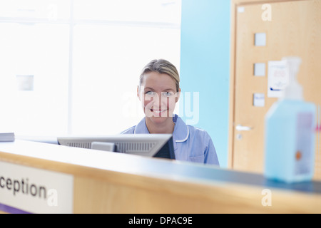 Nurse sitting at reception desk Stock Photo