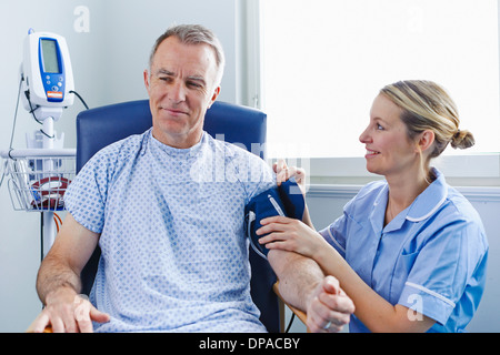 Nurse taking patient's blood pressure Stock Photo