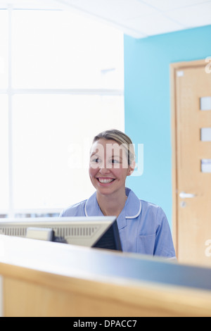 Nurse sitting at reception desk Stock Photo