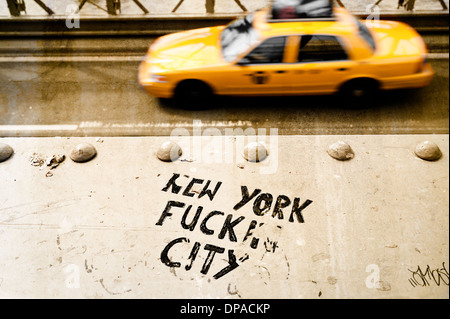 A New York taxi cab drives by graffiti written on the Brooklyn bridge railing Stock Photo