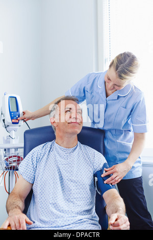 Nurse taking patient's blood pressure Stock Photo