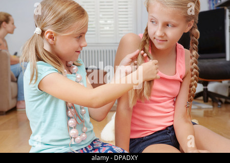 Girl plaiting sister's hair Stock Photo