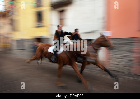 Couple ride reckless horserace 'Sa Carrela e Nanti', during the carnival at Santu Lussurgiu, Oristano, Sardinia, Italy, Europe Stock Photo