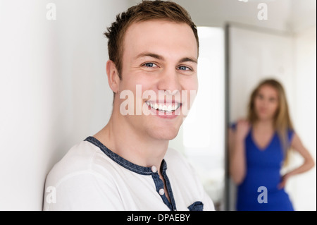 Close up portrait of young man with female in background Stock Photo