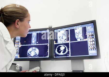 Female doctor examining ct scans on computer monitors Stock Photo