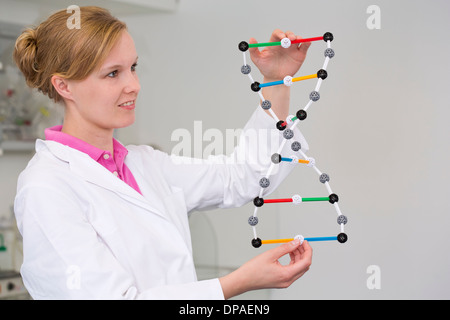 Female scientist with dna molecular model in laboratory Stock Photo