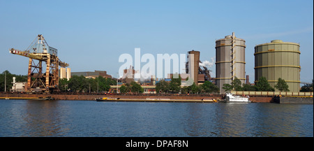 Overhead crane and barges docked at steelworks of ArcelorMittal, world's largest steel producer, Ghent port, Flanders,Belgium Stock Photo