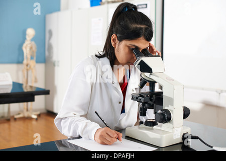 Chemistry student using microscope in laboratory Stock Photo