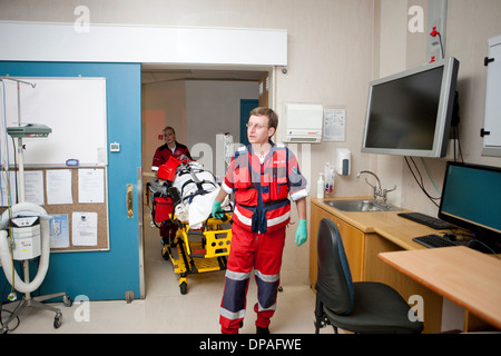 Paramedics moving patient to emergency room in hospital Stock Photo