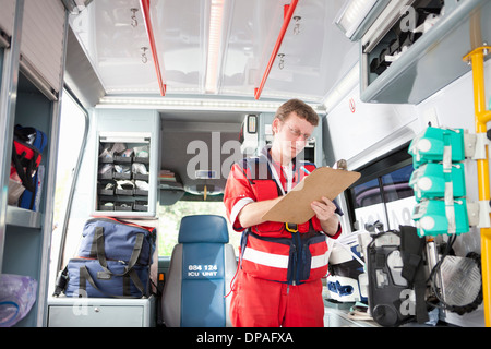 Paramedic in ambulance listing equipment Stock Photo
