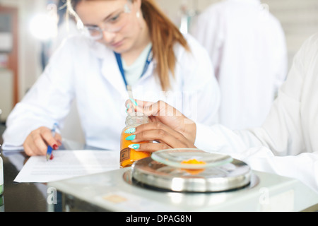 Chemistry students weighing chemicals on scales Stock Photo