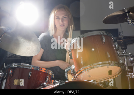 Female drummer sitting behind drums Stock Photo