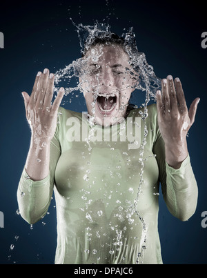 Young woman splashing water on face Stock Photo