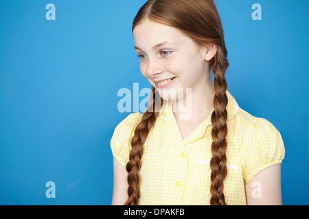 Portrait of girl with plaits wearing yellow school dress Stock Photo