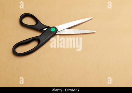 A black dressmaker scissors on a background of a wrapping paper Stock Photo