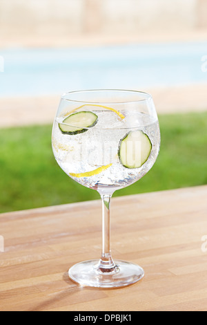 Cucumber gin and tonic cocktail on poolside bar Stock Photo