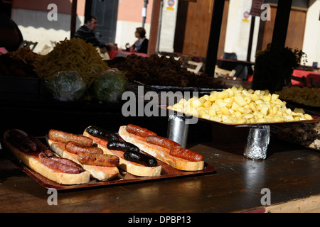 sandwiches topped with fried ausages and potaotoes on stand in the annual All Saints Market in Cocentaina, Alicante ,Spain Stock Photo