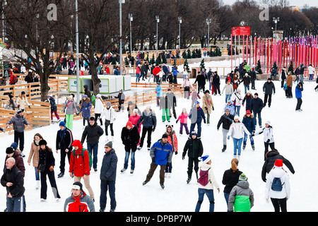 crowds of townsfolk skating rink on ice covered paths in Gorky Central Park on winter weekends Stock Photo