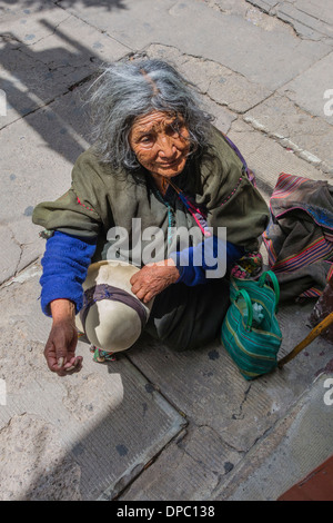 An older indigenous woman beggar on the sidewalk in Sucre, Bolivia. Stock Photo