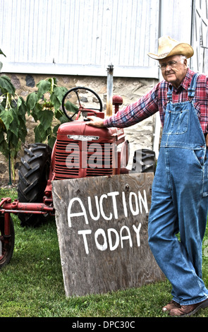 Farmer in front of his tractor that he will be auctioning off today Stock Photo