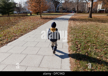 Boy walking on path Stock Photo