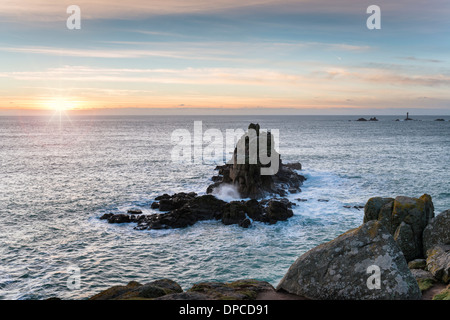 Rocky cliffs at Lands End in Cornwall with the Longships lighthouse in the distance Stock Photo