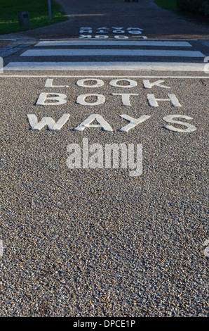 Look both ways painted on footpath to advice pedestrians before they cross the road. Stock Photo