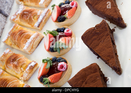 Pastries Tarts and Brownies Cakes for sale on White Table Cloth Stock Photo