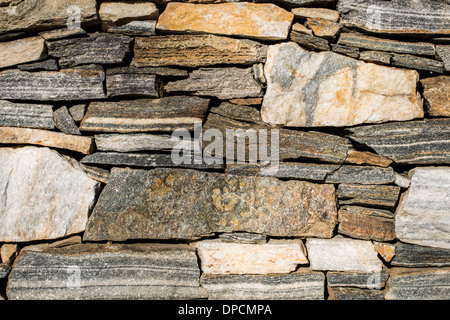 Wall built of stones. Densely arranged stones. Sun light Stock Photo