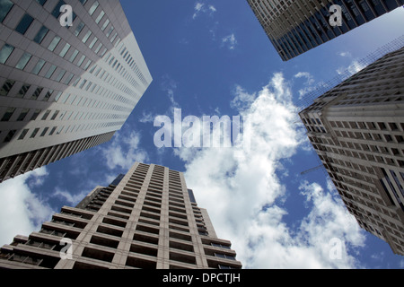Four tall buildings 'converging' with a bright cloudy sky Stock Photo