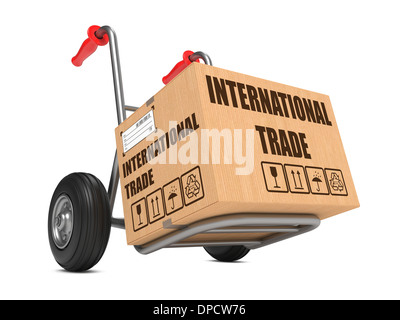 Cardboard Box with International Trade Slogan on Hand Truck White Background. Stock Photo