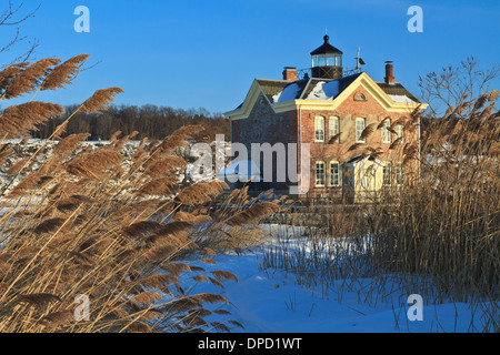 Windswept sea oats front the snow clad Saugerties Lighthouse on the frozen Hudson River in Upstate New York Stock Photo